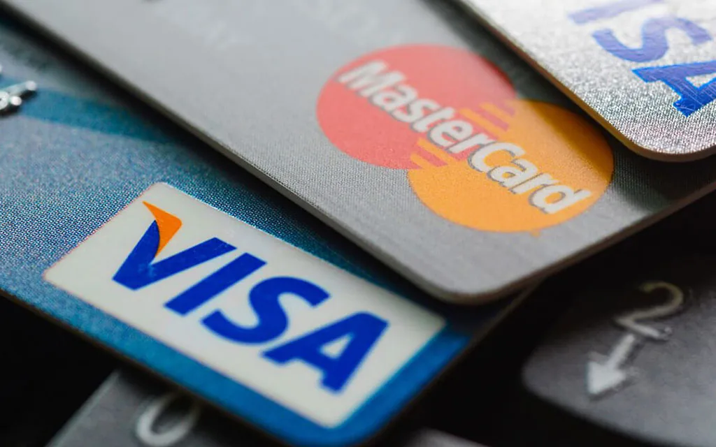 Stack of Visa and Mastercard credit cards representing debt to consolidate