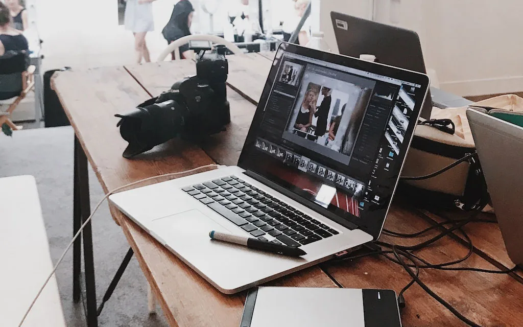 Creative workspace with laptop and camera, representing a personal loan for debt consolidation