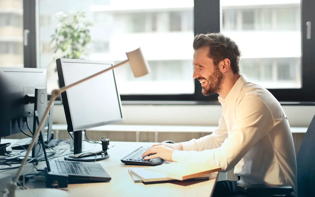 Man working at a dual-monitor desk setup, representing a personal loan for home improvement