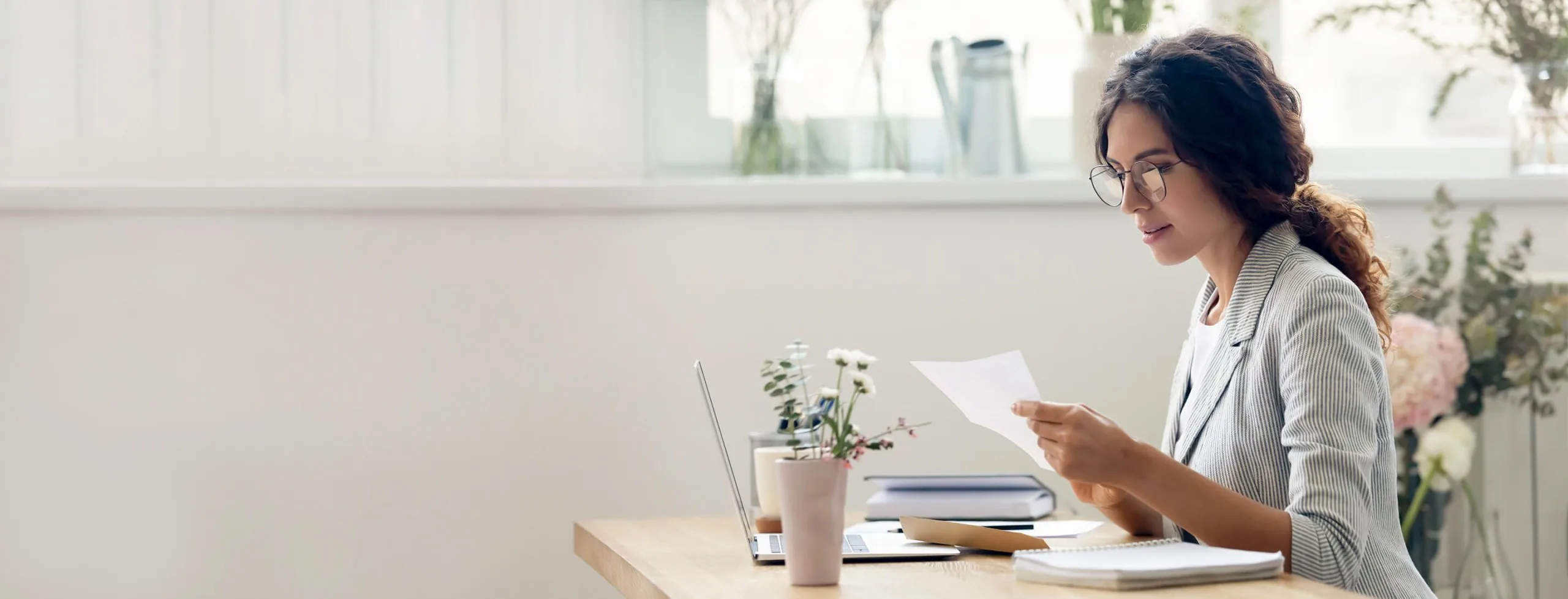 Woman reviewing paperwork for her personal loan application at her desk
